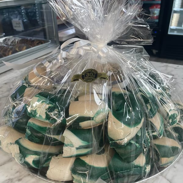 A gift basket of green and white marbled cookies, wrapped in cellophane with a white ribbon.